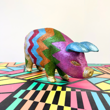 Load image into Gallery viewer, Colorful upcycled glittery wooden pig on a geometric-patterned surface