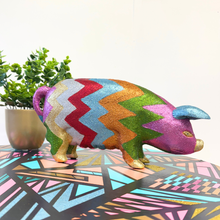 Load image into Gallery viewer, Colorful upcycled glittery wooden pig on a geometric-patterned surface