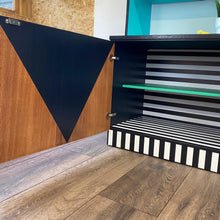 Load image into Gallery viewer, Bright yellow, blue, green, pink and lilac painted mid century storage unit with black and white striped detail