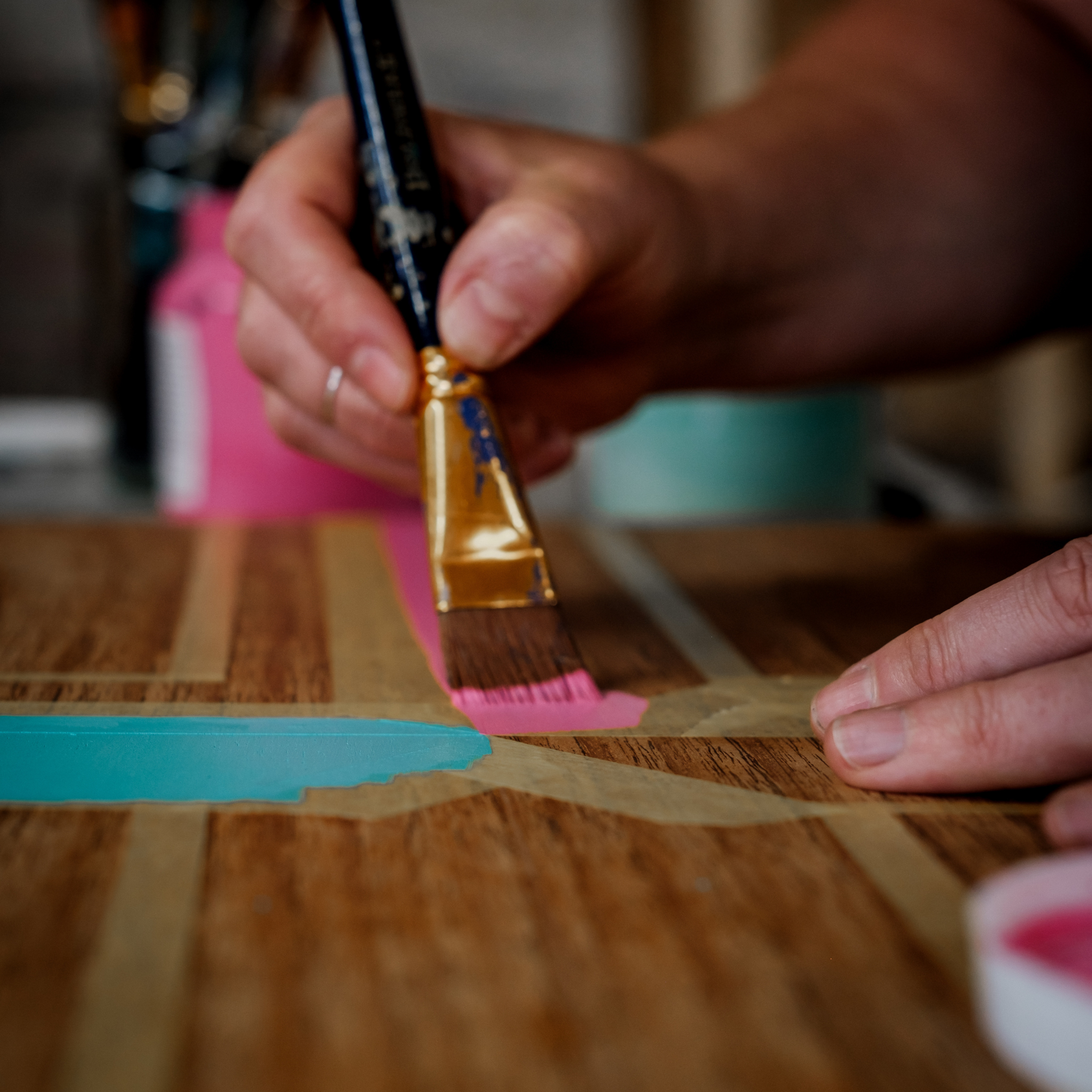 Close up of Amy from Pinkyswifts painting a geometric design on a piece of furniture