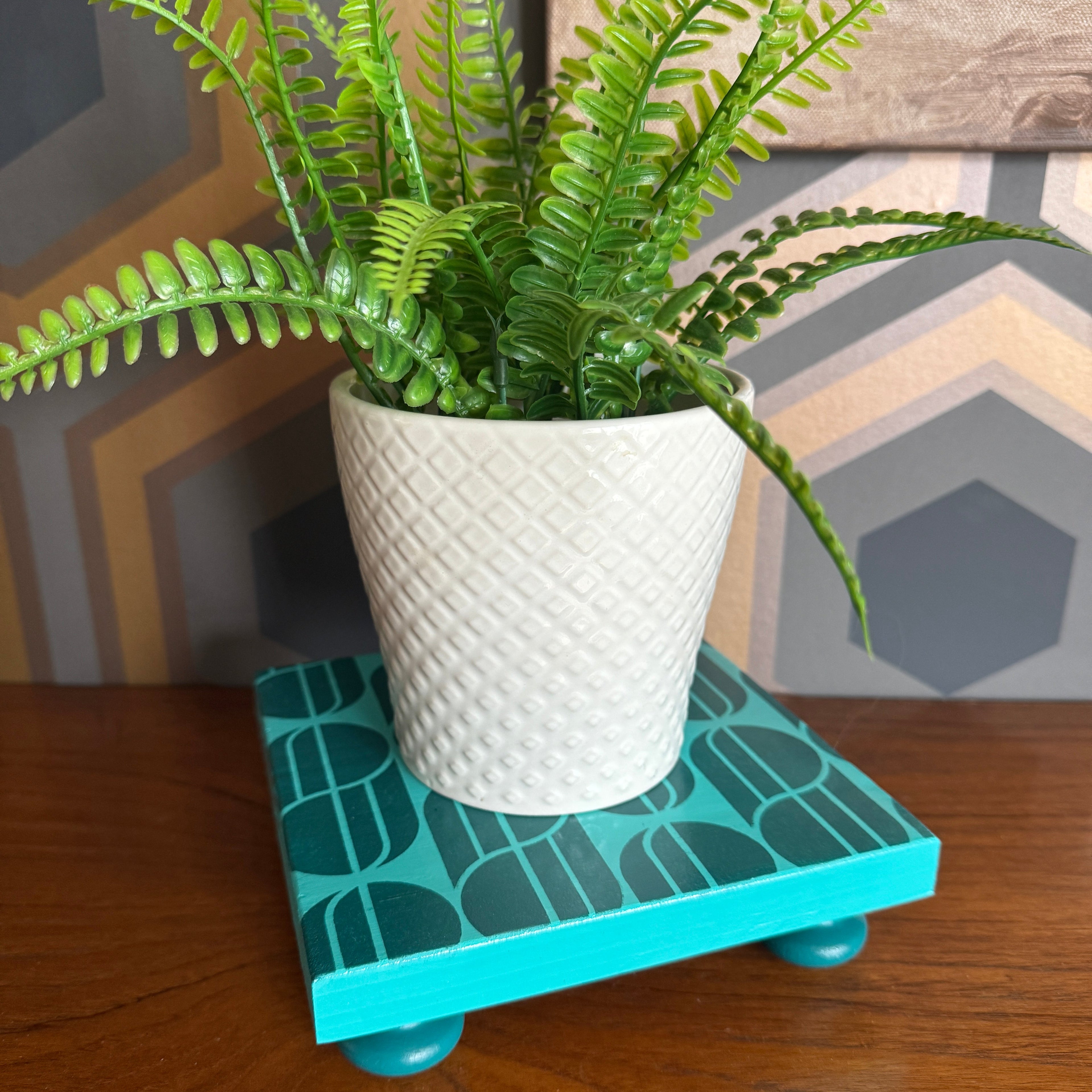 Handpainted reclaimed wooden plant stand displaying a houseplant on a colourful handmade wooden riser made from reclaimed wood.