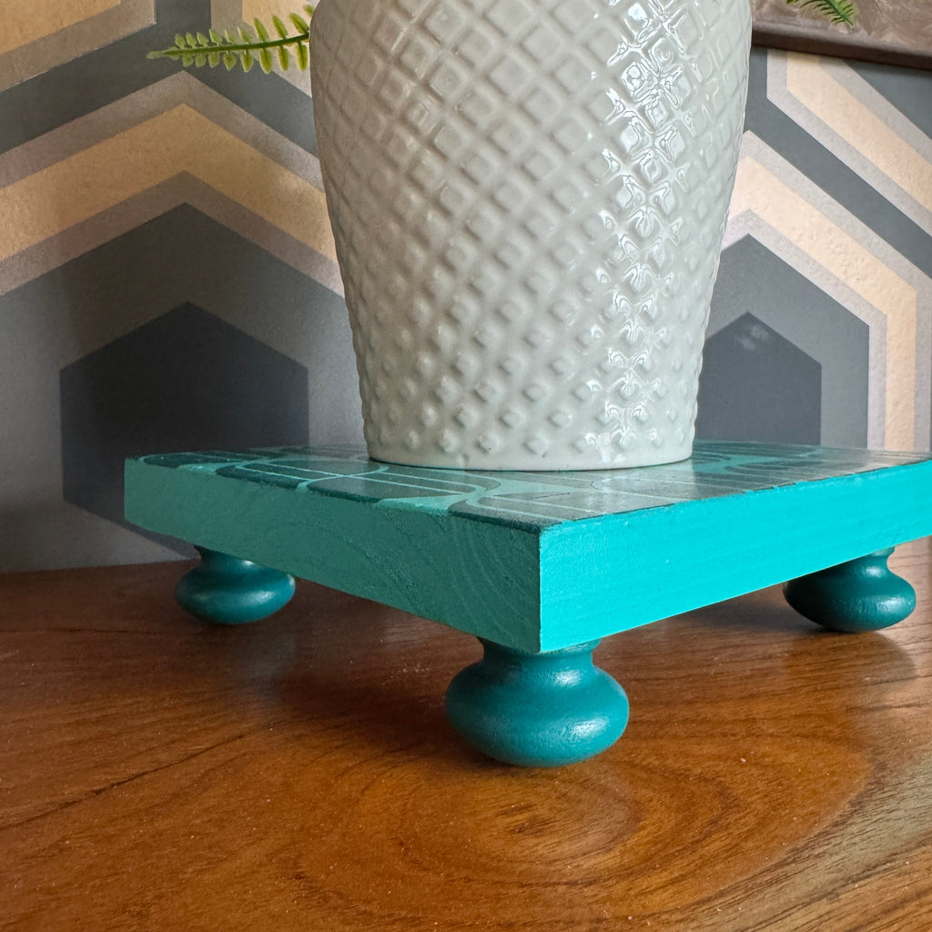Handpainted reclaimed wooden plant stand displaying a houseplant on a colourful handmade wooden riser made from reclaimed wood.