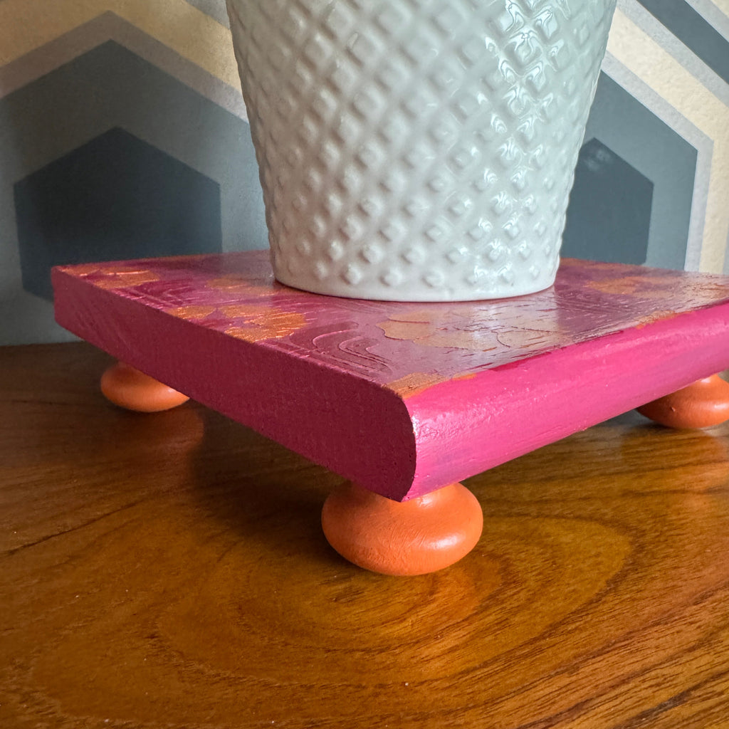 Handpainted reclaimed wooden plant stand displaying a houseplant on a colourful handmade wooden riser made from reclaimed wood.