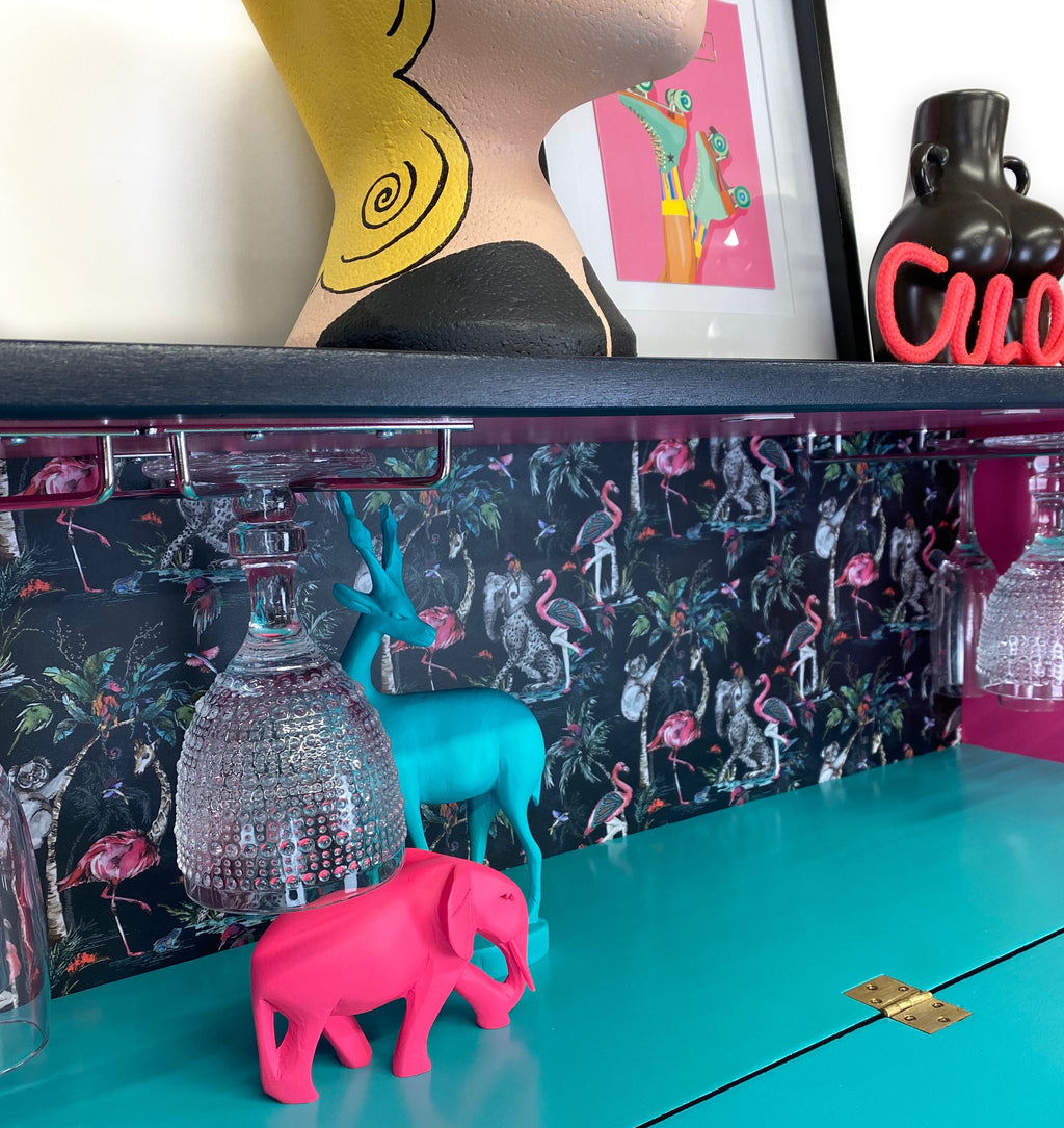 mid century bureau turned into a drinks cabinet and painted in blue pink and silver sunburst design