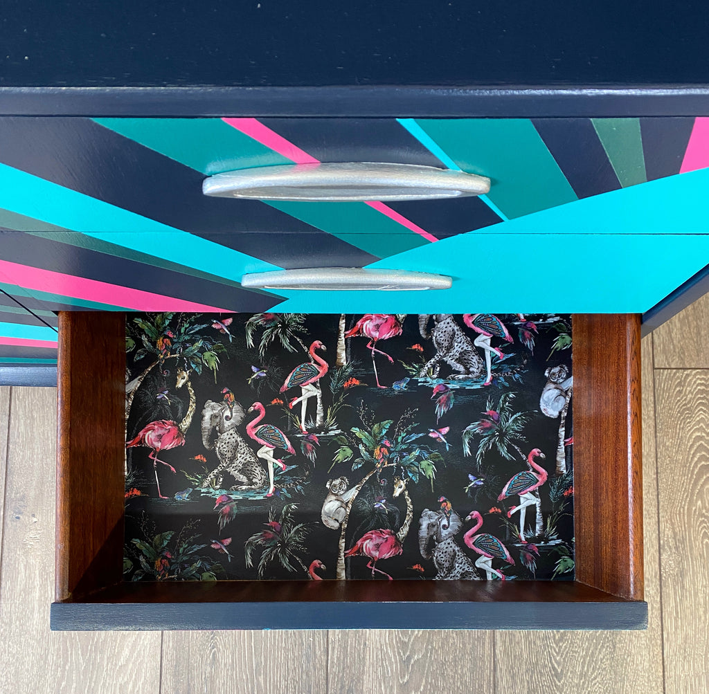 mid century bureau turned into a drinks cabinet and painted in blue pink and silver sunburst design