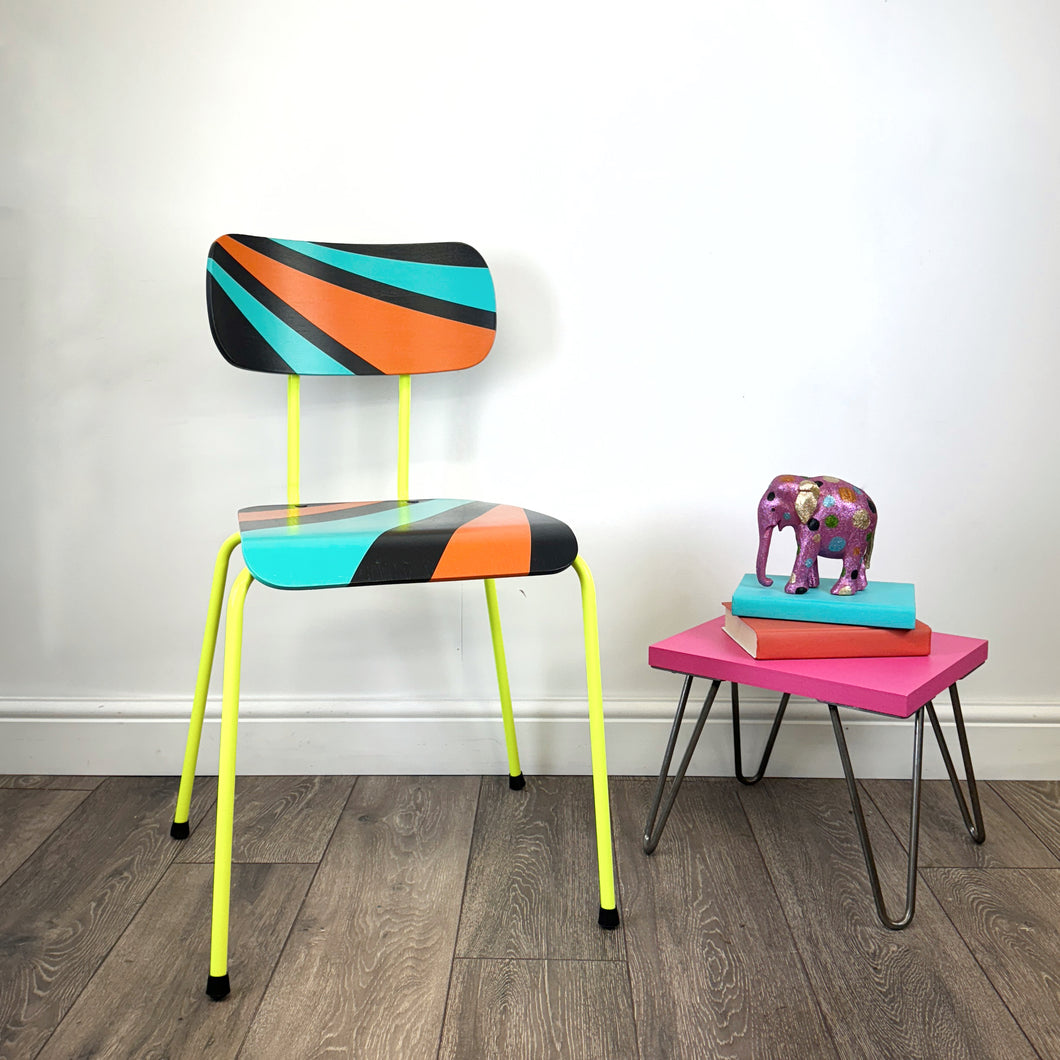 chair with neon yellow legs painted with an orange, blue and black geometric design