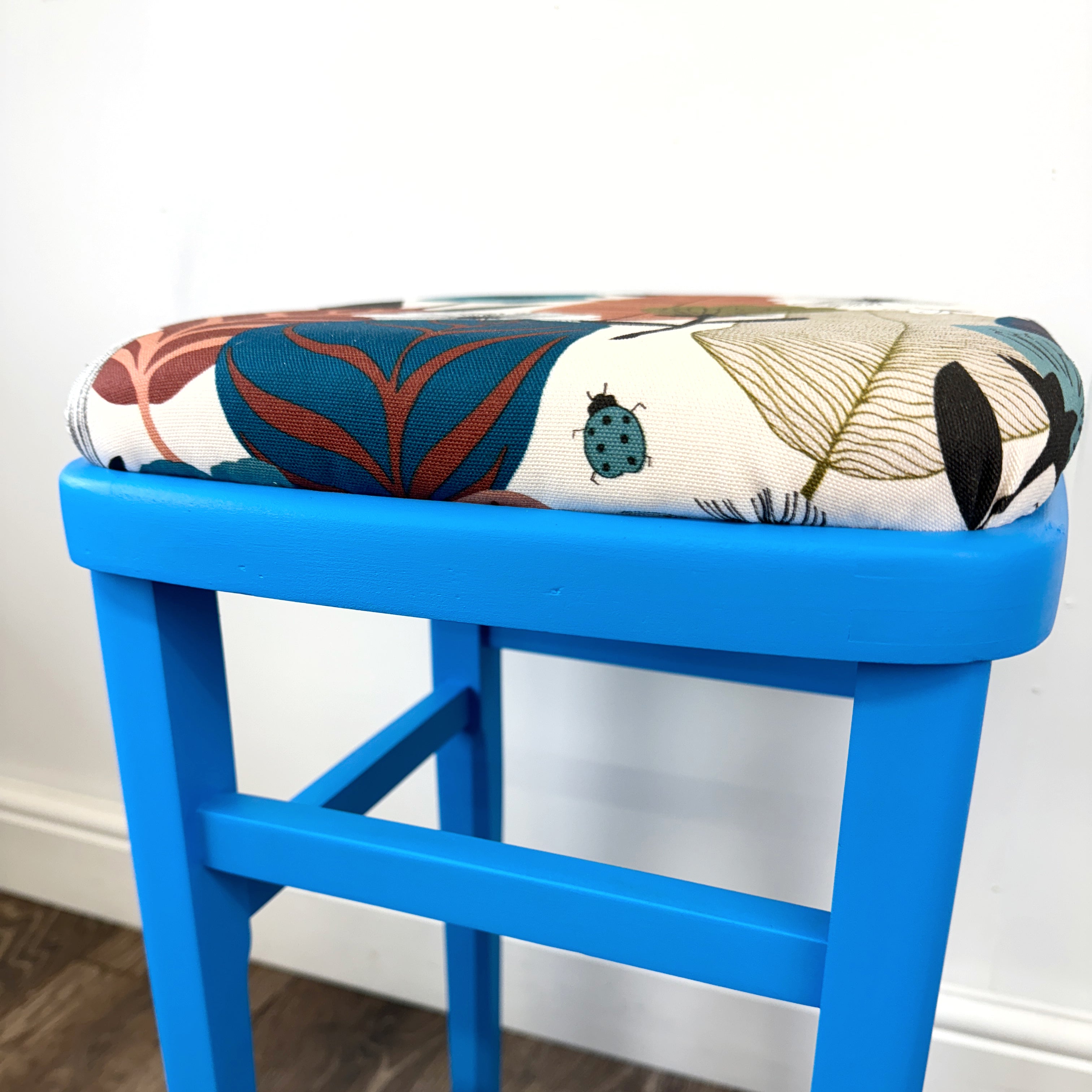blue painted wooden stool with 1950s inspired flower fabric