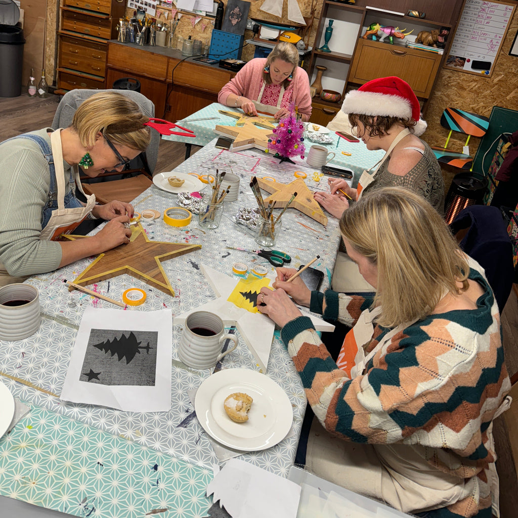UPcycling workshop session with people painting wooden stars