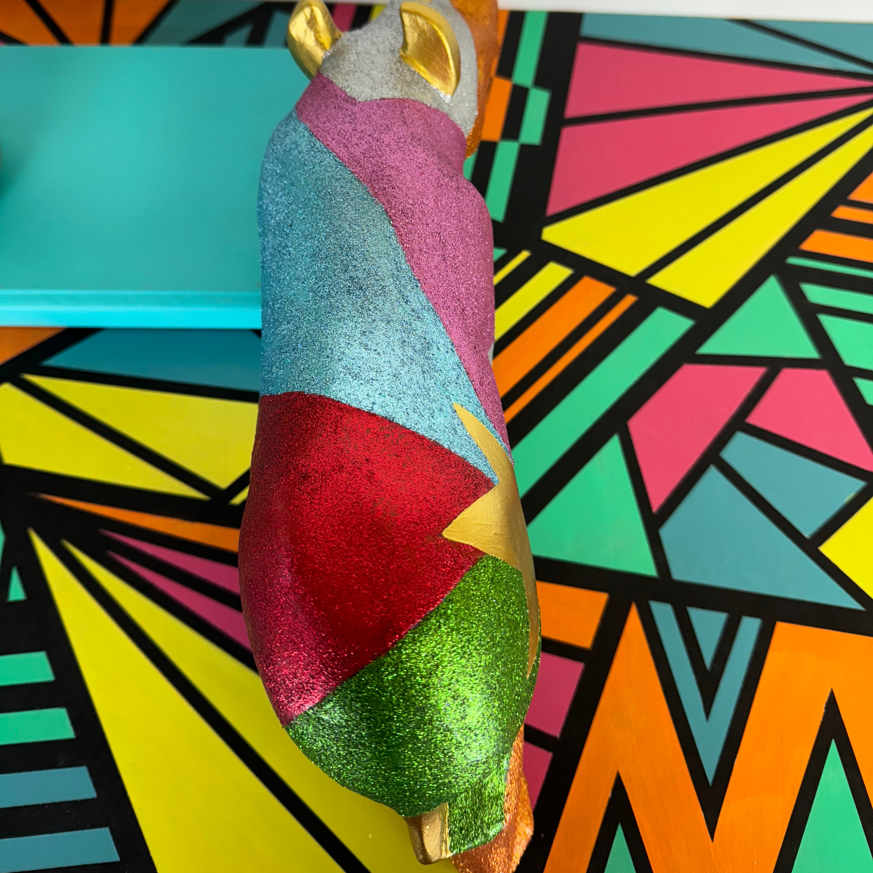 Large wooden rhinoceros handpainted in bright colours, glitter and a gold star design