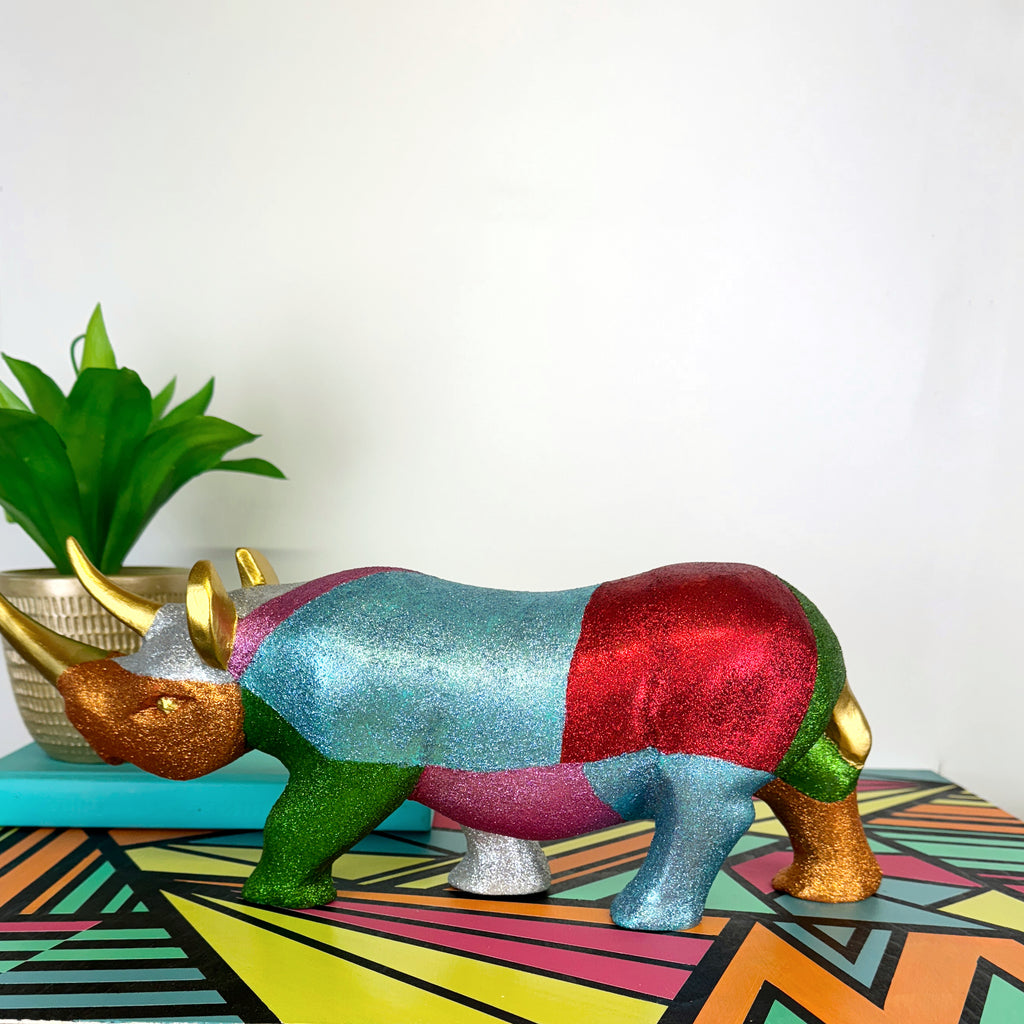 Large wooden rhinoceros handpainted in bright colours, glitter and a gold star design