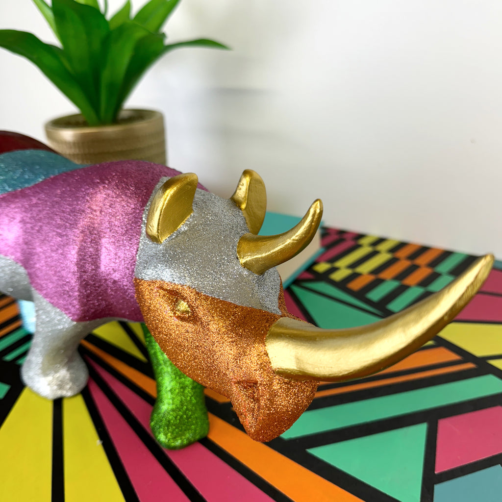 Large wooden rhinoceros handpainted in bright colours, glitter and a gold star design