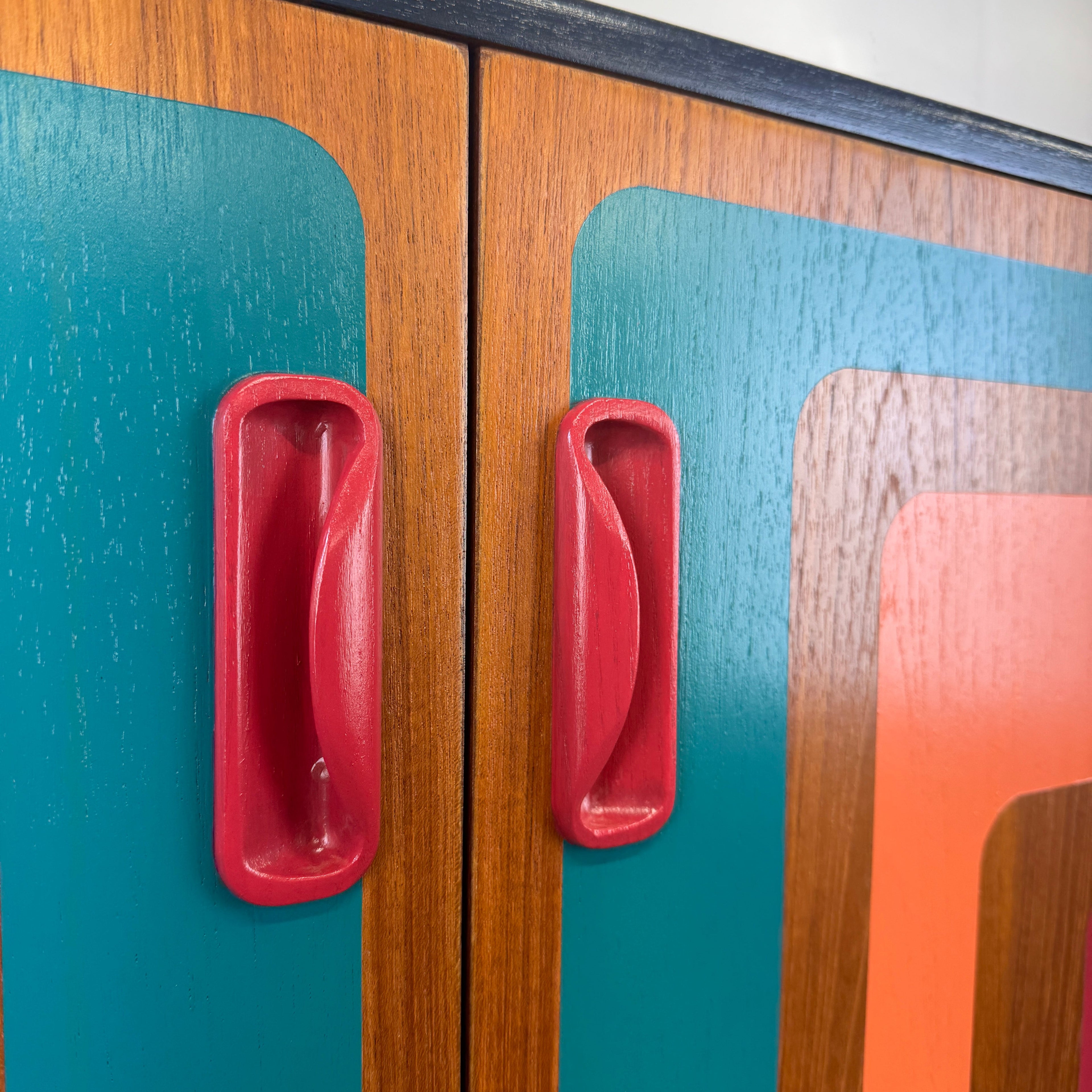 G plan cabinet handles painted in raspberry paint with retro design