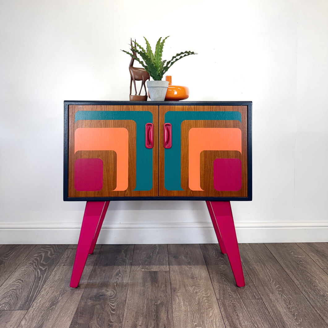 Colorful G Plan cabinet handpainted with abstract design on a wooden floor
