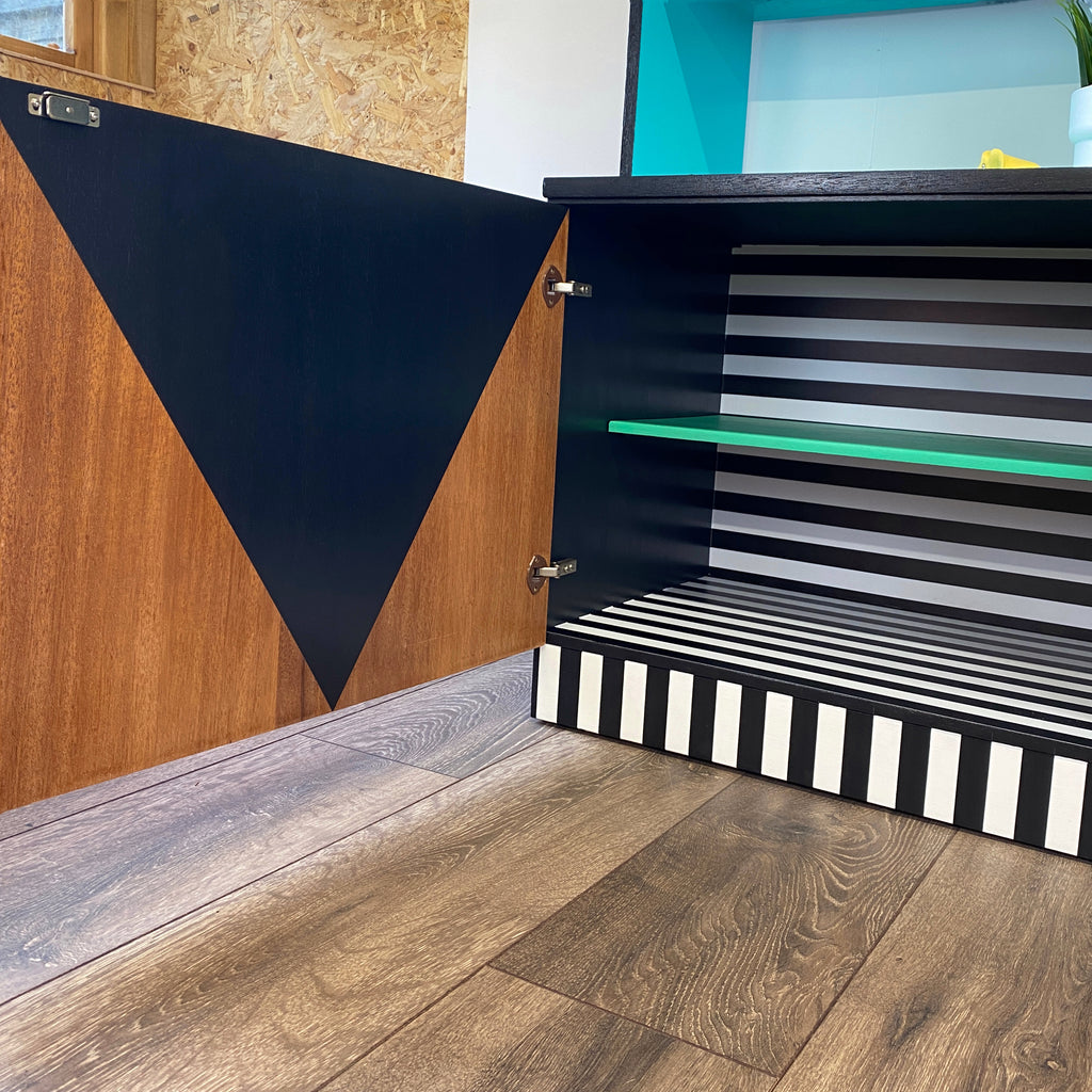 Bright yellow, blue, green, pink and lilac painted mid century storage unit with black and white striped detail