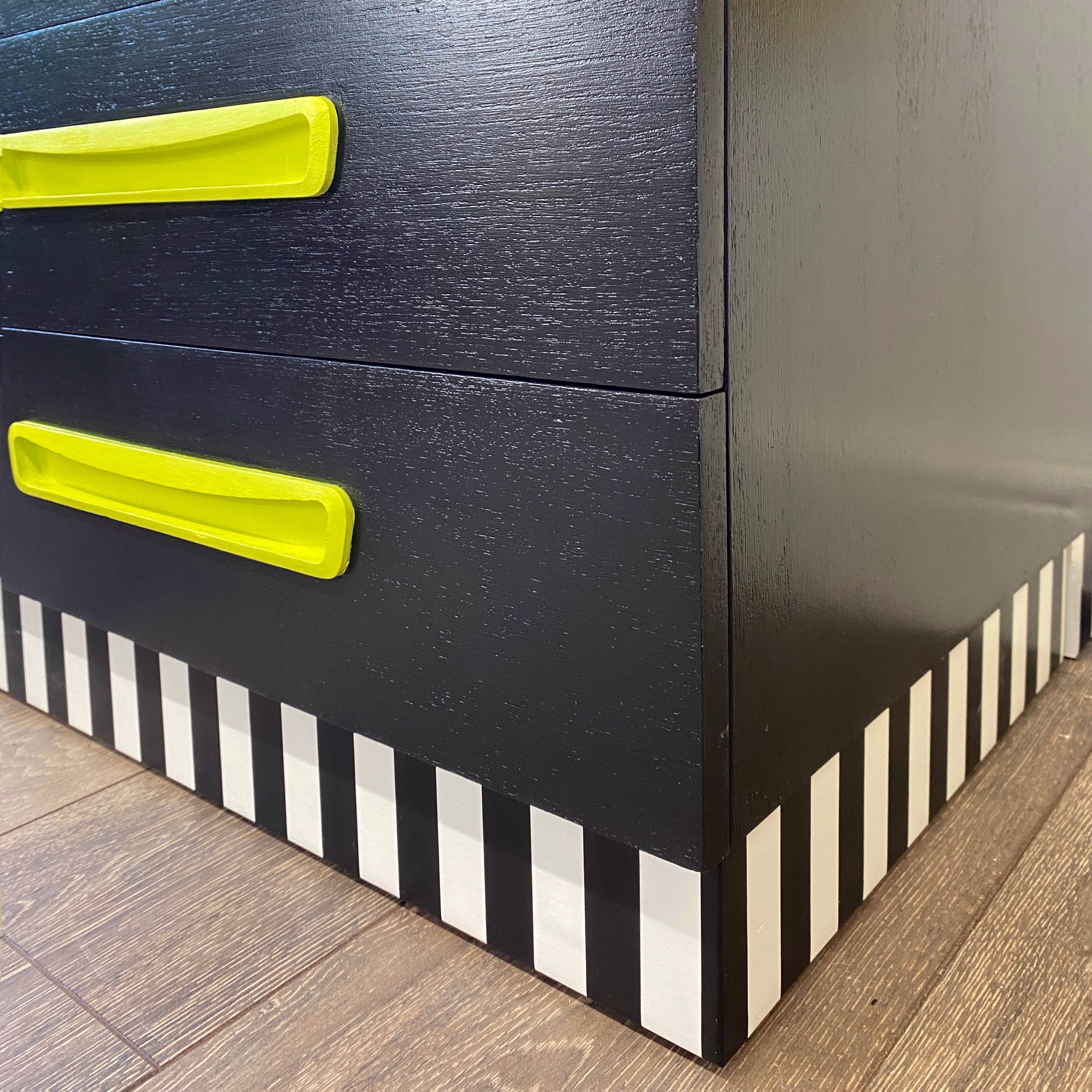 Bright yellow, blue, green, pink and lilac painted mid century storage unit with black and white striped detail
