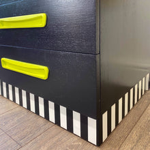 Load image into Gallery viewer, Bright yellow, blue, green, pink and lilac painted mid century storage unit with black and white striped detail
